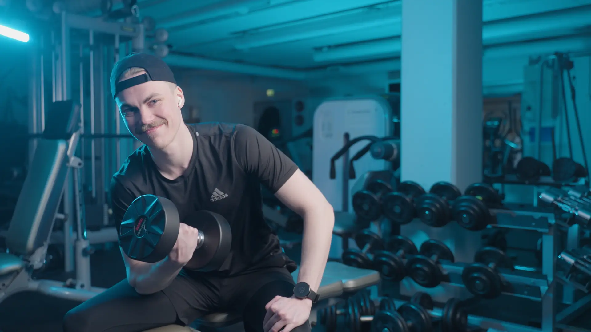 Mies nostaa k&auml;sipainoa kuntosalilla