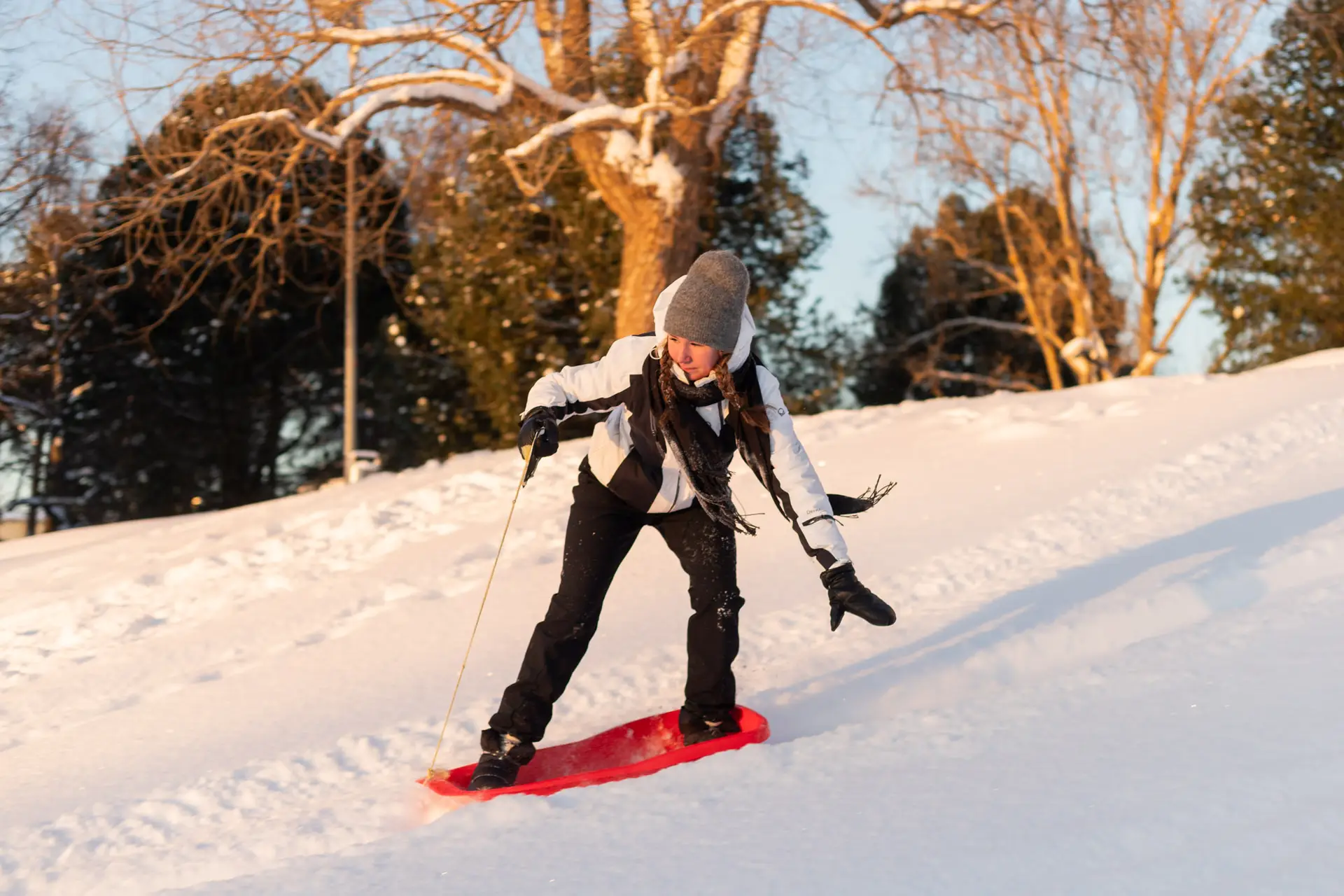 Nainen laskee pulkalla seisaaltaan